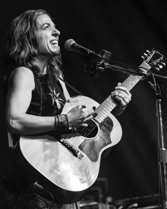 Black and white photo of Ani playing guitar by Emily Butler